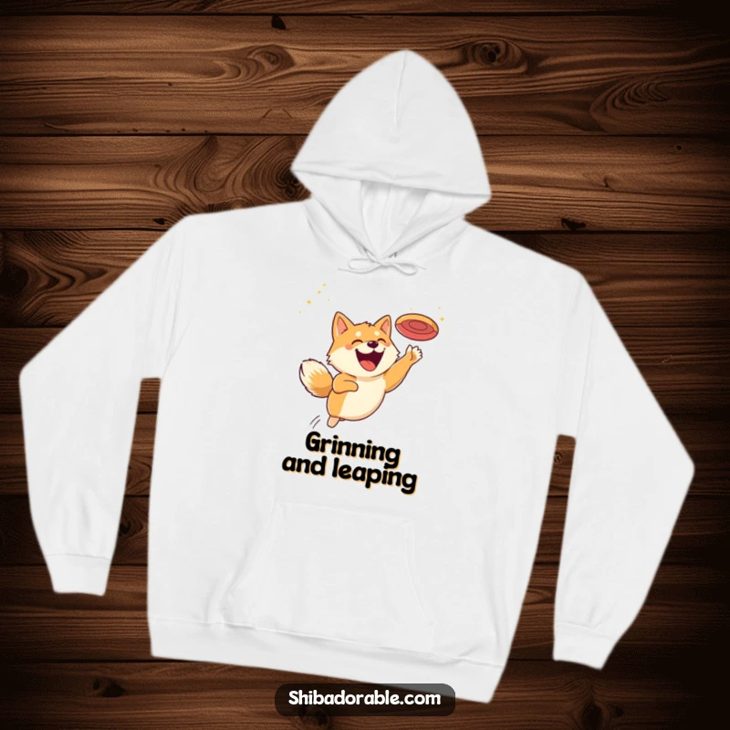 Funny hoodie showcasing a happy Shiba Inu leaping for a flying disc, its face beaming with a huge, infectious grin.