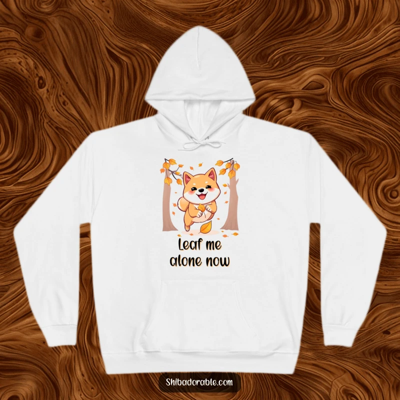 Funny hoodie featuring a happy Shiba Inu playfully leaping to pounce on a falling autumn leaf, radiating autumn excitement.
