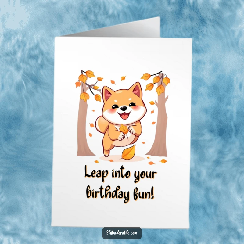 Free Printable Birthday Card: Shiba Inu playfully pouncing on a falling autumn leaf, a downloadable celebration for dog lovers.