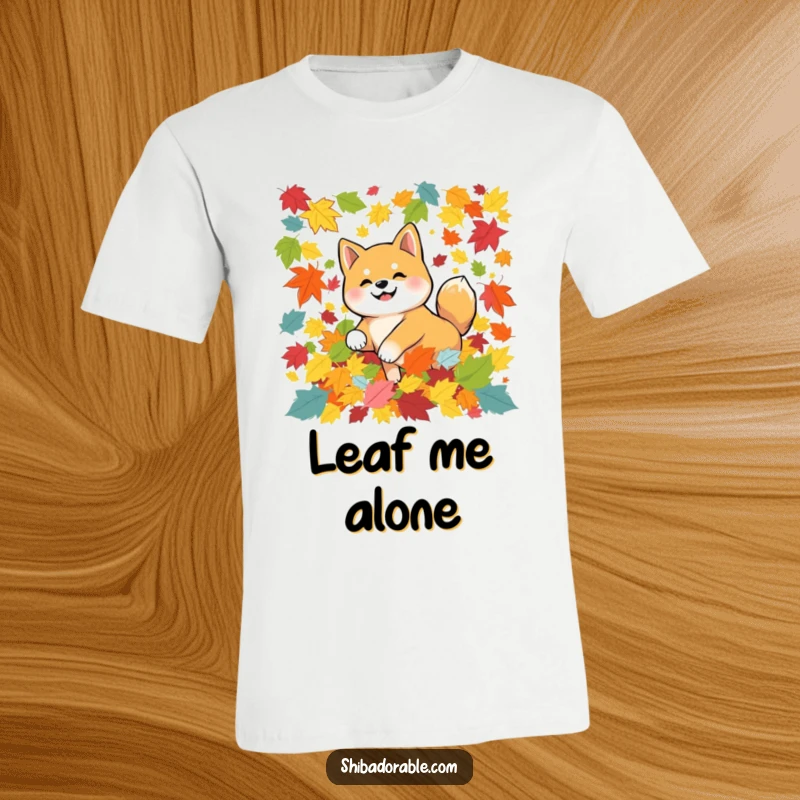 Funny Shiba Inu dog joyfully tumbling amongst colorful autumn leaves, showcased on a comfortable t-shirt for seasonal cheer.